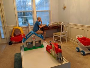 A small working desk is set up in the corner of a playroom.