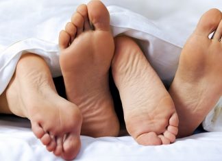 two pairs of feet between the sheets