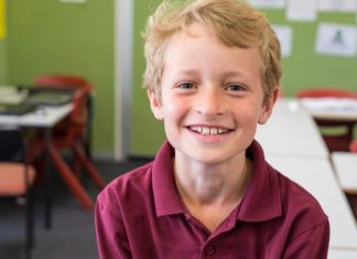 boy smiling in a classroom
