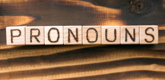 the word "pronouns" written in wooden letters