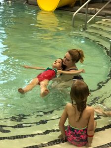 toddler in pool with swim instructor