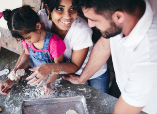 mom and dad making cookies with little girl