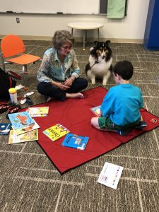 boy reading to a dog at the library