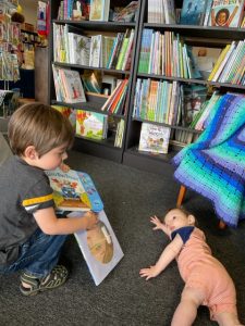 two boys reading books at a local bookshop, Green Door Book Store
